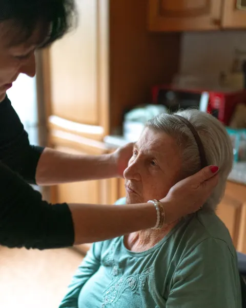 Caregiver attending to a senior woman at home